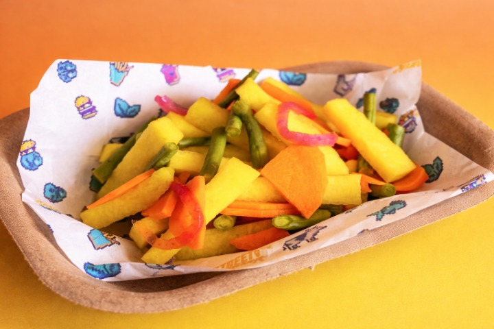 Loaded fries served in custom retro-branded paper with arcade-style graphics
