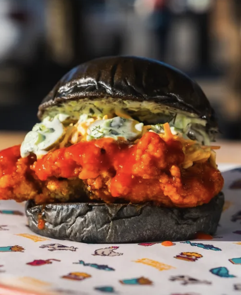 Burger wrapped in custom retro deli paper on a colorful nostalgic tablescape